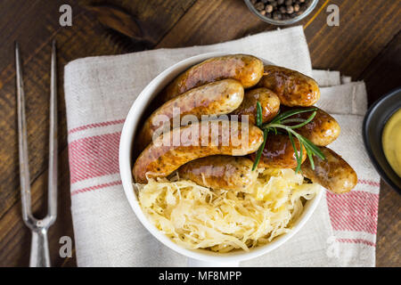 Traditionelle deutsche Würstchen mit Krautsalat, Senf und Bier. Bratwurst und Sauerkraut. Stockfoto