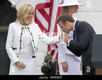 Washington, District of Columbia, USA. 24 Apr, 2018. Präsident Emmanuel längestrich von Frankreich küsse die Hand seiner Frau, Brigitte Längestrich, nach Abschluss der Begrüßungszeremonie auf dem Rasen des Weißen Hauses in Washington, DC am Dienstag, 24. April 2018. First Lady Melania Trump ist dargestellt hinter ihnen. Credit: Ron Sachs/CNP Credit: Ron Sachs/CNP/ZUMA Draht/Alamy leben Nachrichten Stockfoto