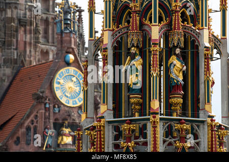 24 April 2018, Deutschland, Nürnberg: Die 'Schoener Brunnen" (Lit. "Schönen Brunnen") in der Altstadt von Nürnberg vor der Kulisse der Frauenkirche. Der Brunnen geht zurück bis in das 14. Jahrhundert und ist mit dem Einfluss der Kaiser Karl IV. in Nürnberg verbunden. Foto: Daniel Karmann/dpa Stockfoto