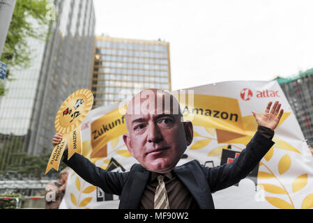 Berlin, Deutschland. 24 Apr, 2018. Ein Demonstrator eines Jeff Bezos hält eine symbolische Auszeichnung in der Luft während der Demonstration gegen die Verleihung des Axel Springer Preis 2018 Amazon Gründer Jeff Bezos für seine "visionären Unternehmertum''. Mitarbeiter des Unternehmens demonstrierten unter dem Motto ''Make Amazon wieder'' gegen die Axel Springer AG den Zuschlag für die herausragende Persönlichkeiten Zahlen, laut Medien, die besonders innovativ sind, erstellen und Märkte verändern und bis zu ihrer sozialen Verantwortung stellen. Credit: ZUMA Press, Inc./Alamy leben Nachrichten Stockfoto