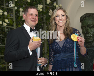 Washington, District of Columbia, USA. 24 Apr, 2018. John Shuster, eine Amerikanische Curler, die led-Team USA Gold bei den Olympischen Winterspielen 2018 und Meghan Duggan, drei Mal Eishockey Olympiasieger, zeigen sie ihre Medaillen, wie sie für die staatliche Abendessen zu Ehren Abendessen zu Ehren Präsident Emmanuel Längestrich der Französischen Republik und Frau Brigitte Längestrich im Weißen Haus in Washington, DC am Dienstag, 24. April 2018. Quelle: Ron Sachs/CNP Credit: Ron Sachs/CNP/ZUMA Draht/Alamy Leben Nachrichten ankommen Stockfoto