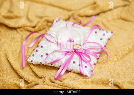 Goldene Hochzeit Ringe auf geschmückten kleinen weißen Kissen. Ehe-Konzept Stockfoto