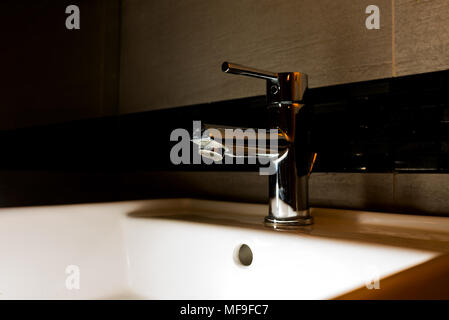 Wasser Schrank in einem dunklen Badezimmer tippen Stockfoto
