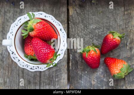 Frische Erdbeeren in einem Porzellan Schale auf Holz-, vintage Hintergrund Stockfoto