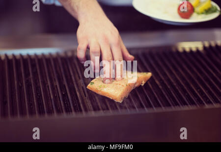 Meisterkoch Hände kochen gegrillter Lachs Fisch mit Kartoffeln auf ein Restaurant Küche Stockfoto