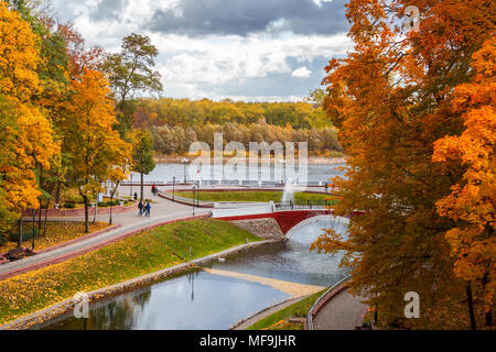 Eine schöne Gasse von bunten Bäumen im Park. Herbst Landschaft. Schöne bunte Bäume auf dem Hintergrund der Fluss. Stockfoto