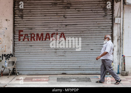 Panama City, Panama - März 2018: alte Person auf dem Bürgersteig vor der Apotheke auf der belebten Einkaufsstraße in Panama City, Avenida Central Stockfoto