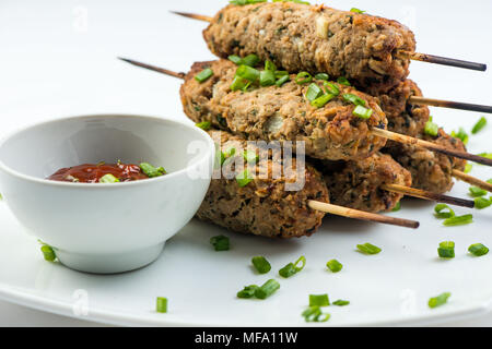 Kebab mit Kräutern auf einem weißen Teller auf weißem Hintergrund Stockfoto