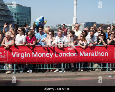 Anzeigen von Zuschauern gesäumt, gegen eine Barriere Aufpassen der London Marathon 2018 Stockfoto