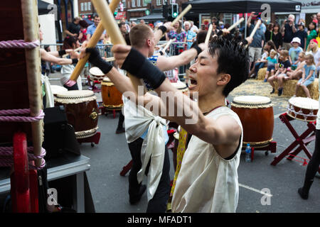 Musiker schlagen große Japanische ō-daiko Trommel mit Bachi sticks für Joji Hirota & London Taiko Trommler bei Whitton St. George's Day Festival 2018 Stockfoto