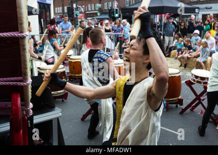 Musiker schlagen große Japanische ō-daiko Trommel mit Bachi sticks für Joji Hirota & London Taiko Trommler bei Whitton St. George's Day Festival 2018 Stockfoto