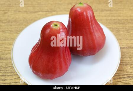 Frische rote reife Wasser Äpfel, Rose Äpfel, Wasser Guave oder Jambu Air auf einem weißen Teller. Stockfoto