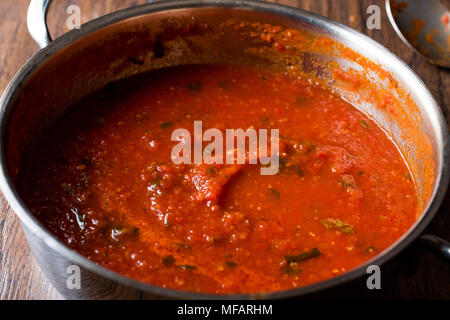 Tomatensoße mit Kräutern in Metall Pot. Ökologische Lebensmittel. Stockfoto