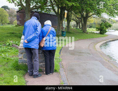 April 2018 - älteres Ehepaar das Auschecken eines Information Board in einem öffentlichen Park. Stockfoto