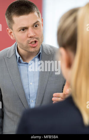 Aggressive Geschäftsmann Mobbing Kollegin im Büro Stockfoto