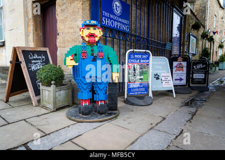 Eine Sammlung von Schilder am Eingang der Woolmarket Einkaufsviertel in Cirencester einschließlich einer Lego Statue Stockfoto