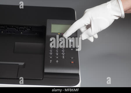 Woman's Hände in weißen Handschuh durch Drücken der Taste auf dem Bedienfeld Farb Laser Drucker im Büro oder Geschäft Stockfoto