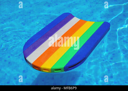 Rainbow Muster Styropor schwimmen oder Baseboard floating im Schwimmbadwasser, Sommer Urlaub Freizeitgestaltung Objekt im Pool Stockfoto