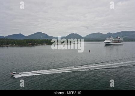 Ein Schnellboot rennen hinter einem Kreuzfahrtschiff der Tongass verengt, in der Nähe von Ketchikan, Alaska. Stockfoto