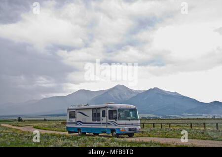 Eine große Klasse ein Reisemobil Antriebe eine unbefestigte Straße an der Unterseite des Einfassung Princeton in der Nähe von Buena Vista, Colorado. Ein Sommer regen Sturm weht. Stockfoto