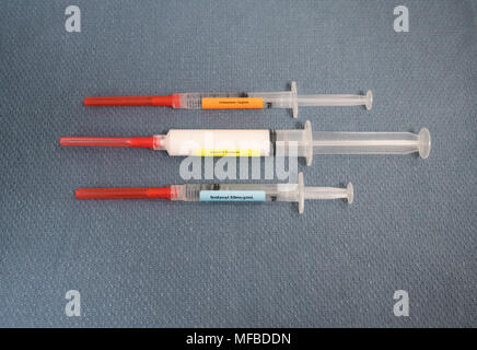 Drei beschriftet Spritzen mit Rot bedeckte Sicherheit Nadeln mit Medikamenten für Anästhesie - fentanyl, Propofol und Midazolam. Sie sind auf einer b Stockfoto