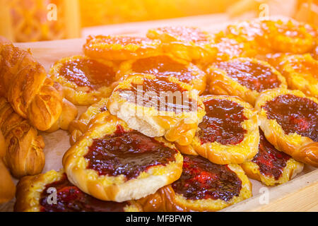 Nahaufnahme der frische und köstliche Brötchen mit einer Beere, Cowberry in einem Schaukasten in einer Bäckerei Stockfoto