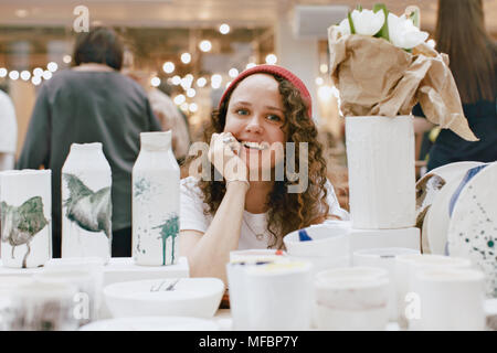 Charmante Frau unter Ton artisan Utensil Stockfoto