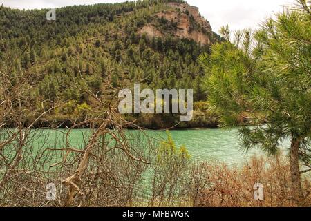 Tolosa Behälter durch die Vegetation und die Berge in Alcala del Jucar Dorf umgeben, Albacete, Spanien Stockfoto