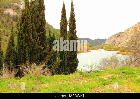 Tolosa Behälter durch die Vegetation und die Berge in Alcala del Jucar Dorf umgeben, Albacete, Spanien Stockfoto