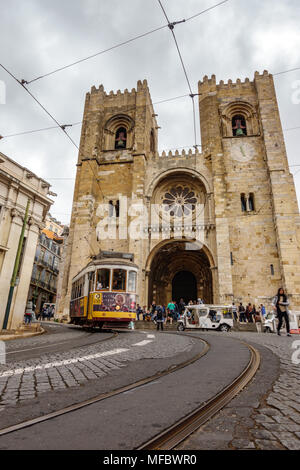 Lissabon - 3. April: Die berühmten 28 Straßenbahn steigt in der Nähe von Cathedral Hill mit Touristen und Autos am 3. April 2018 in Lissabon, Portugal Stockfoto