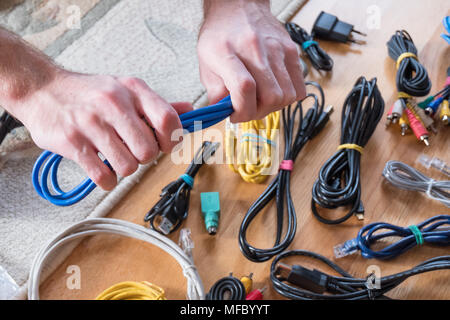 Männliche Hände halten blaues Kabel Stockfoto