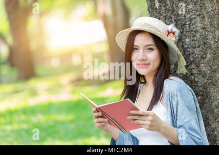 Schöne asiatische Frau Rosa Buch im Park liebe Speicher oder Tagebuch Stockfoto