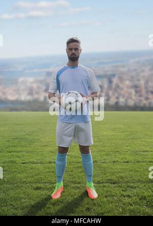 Fußball-Spieler auf Gras mit Stadt Stockfoto