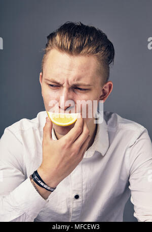 Junger Mann Verkostung Zitrone. Stockfoto