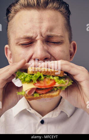 Junger Mann das Essen einer frischen Burger Stockfoto