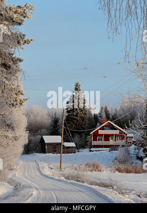 Snowy land Straße führt in ein kleines Haus auf einem Hügel Stockfoto