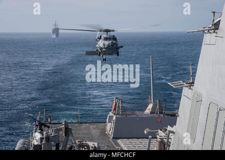 Pazifik (21. April 20180 einem MH-60R Helikopter Hubschrauber Maritime Strike Squadron (HSM) 71 Ansätze das Flight Deck der USS Stockdale (DDG106) während einer laufenden Cruiser-Destroyer (ROHÖLSORTEN) Oberfläche Kriegsführung Advanced Tactical Training (SWATT) Übung. Stockdale ist einer von drei ROHÖLSORTEN Kriegsschiffe aus USS John C Stennis (CVN 74) Carrier Strike Group (CSG) Abschluss einer ROHÖLSORTEN SWATT Übung. Die anderen Schiffe, die an der Oberfläche und Mine Warfighting Development Center (SMWDC) LED-Übung sind USS Mobile Bay (CG53) und USS Spruance (DDG111). SWATTs sind darauf ausgelegt, zu erhöhen. Stockfoto