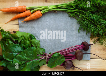 Junge frisch gepflückte Rote Beete und Möhren auf einem hölzernen Hintergrund. top View Stockfoto