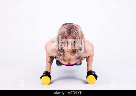 Passende Frau im Sport Kleidung pushups auf kurzhanteln Stockfoto