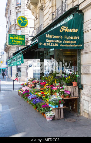 Paris, Frankreich, 23. März 2015: ein Blumenhändler auf einer Pariser Straße bietet eine Fülle von Blumen draußen sitzen. Stockfoto