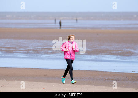 Crosby, Merseyside. 25. April 2018. Einen kühlen und windigen Start in den Tag über den Nordwesten von England als alleinreisende Frau joggt entlang der Küste auf dem Sand Crosby Strand in Merseyside. Credit: cernan Elias/Alamy leben Nachrichten Stockfoto