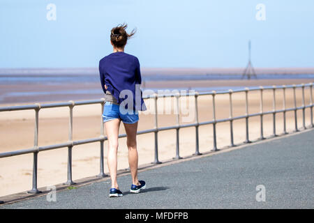 Crosby, Merseyside. 25. April 2018. Einen kühlen und windigen Start in den Tag über den Nordwesten von England als einsame Frau Spaziergänge entlang der Küste mit ihrem Haar weht im Wind am Crosby Beach in Merseyside. Credit: cernan Elias/Alamy leben Nachrichten Stockfoto