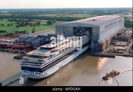 Die 77.000 Tonnen schwere Kreuzfahrtschiff 'Mercury' gleitet aus der überdachten Gebäude Dock der Meyer Werft in Papenburg am 11. Juli 1997 wie eine Garage. Dies ist das 264 Meter lange und 32,2 Meter breite Schwesterschiff lieferte im vergangenen Jahr 'Galaxy' - die beiden kreuzfahrer sind der größte jemals in Deutschland eingesetzte Fahrgastschiffe gebaut. Die für 1870 Passagiere konzipiert 'Mercury' wird in diesen Tagen an den Anlagen Pier der Werft abgeschleppt werden. Nach der geplanten Uberfuhrungsfahrt auf der Ems in die Nordsee, das Schiff ist im Oktober 1997 an die Reederei Celebrity Cruises (Miami). | Verwendung weltweit Stockfoto