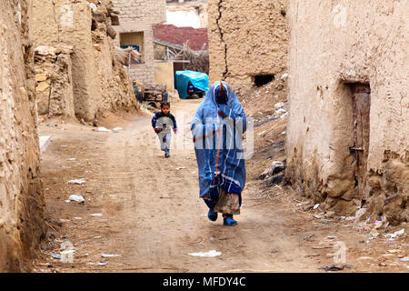 Eine Frau in einer Burka hinunter die Straße der alten Stadt von Siwa, Ägypten Stockfoto