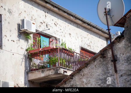 Ein Balkon von Bullet beschädigte Wände in Mostar, Bosnien und Herzegowina umgeben Stockfoto