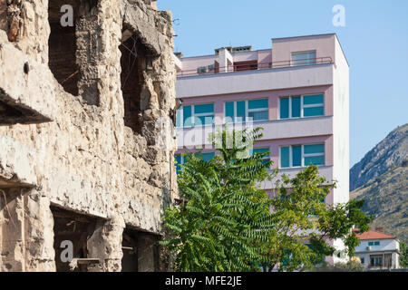 Ein zerbombten Gebäude aus den Bosnischen Krieg weiter in ein neues Gebäude in Mostar, Bosnien und Herzegowina Stockfoto