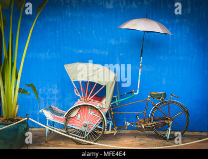 Altes Fahrrad rickshaw, Rikscha auf der blauen Wand, Cheong Fatt Tze Mansion, blaue Villa, Leith Street in Georgetown, Penang Stockfoto