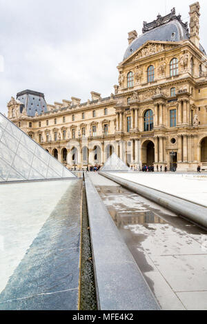 Paris, Frankreich, 22. März 2015: An einem bewölkten Tag im Frühjahr befindet sich das Louvre Museum mit der Glaspyramide im Vordergrund. Stockfoto