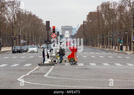 Paris, Frankreich, 22. März 2015: mit Blick auf den Arc de Triomphe entlang der Av. de Champs Elysees an einem bewölkten Tag in Paris. Mit fahrradrikscha Kreuzung Stockfoto