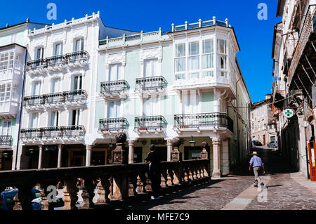 Mann zu Fuß durch die schöne Gebäude und gepflasterte Straße am Cathedral Square. Mondoñedo, Lugo, Galizien, Spanien. Stockfoto